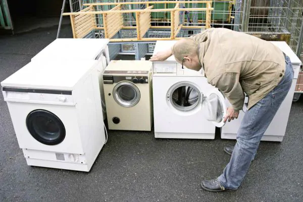 home owner looking at their old washer and dryer