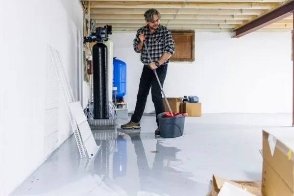 male cleaning basement with mop